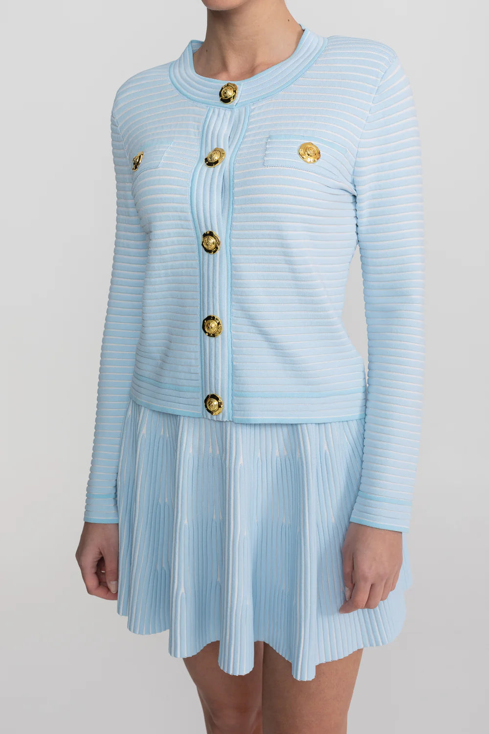 Conjunto em Tricô Estruturado -  Cardigan com Botões Dourados e Saia Plissada